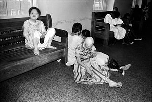 Black and white photo of children with developmental disabilities, some laying on the floor, dirty, some in hospital gowns, neglected.