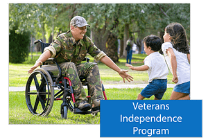A button that says Veterans Independent Program place in the lower right hand corner of an image of a man in a wheelchair wearing military fatigues with outstretched arms as his two children run towards him for a hug.