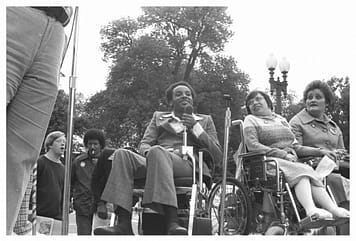 Brad Lomax, the founder of the D.C. chapter of the Black Panther Party, in a wheelchair, center, next to the activist Judy Heumann, also in a wheelchair, at a rally in 1977 at Lafayette Square in Washington.